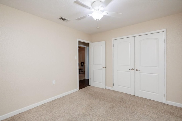 unfurnished bedroom featuring carpet, a closet, visible vents, ceiling fan, and baseboards