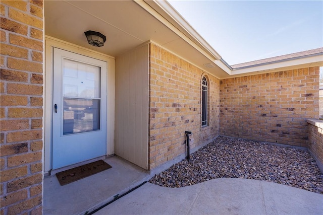 doorway to property featuring brick siding