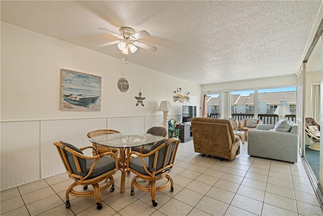 14810 Windward Dr Unit 301, Corpus Christi, TX 78418 - dining area featuring ceiling fan, a textured ceiling, wainscoting, and light tile patterned floors