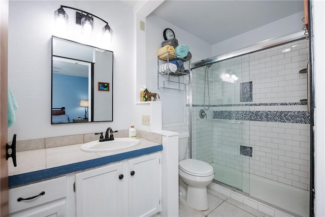 ensuite bathroom featuring tile patterned floors, a shower stall, toilet, and vanity