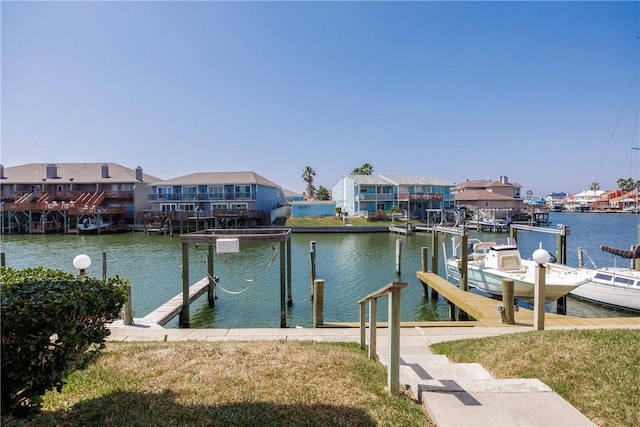 dock area with boat lift, a residential view, and a water view