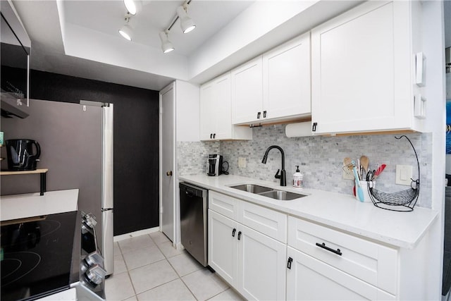 kitchen with backsplash, light countertops, appliances with stainless steel finishes, light tile patterned flooring, and a sink