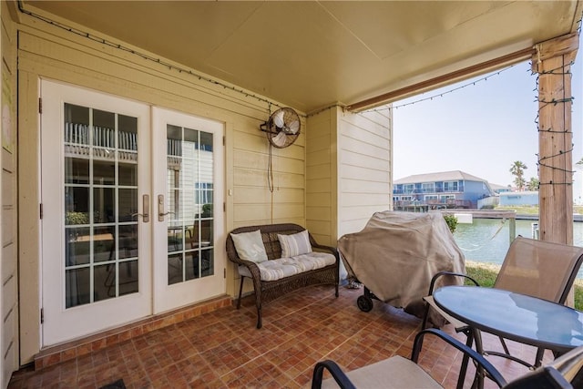 balcony with a water view, a patio, french doors, a grill, and outdoor dining area