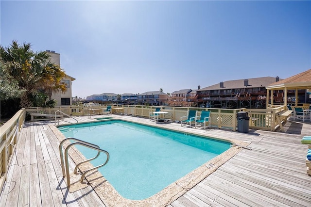 pool with a wooden deck and a residential view