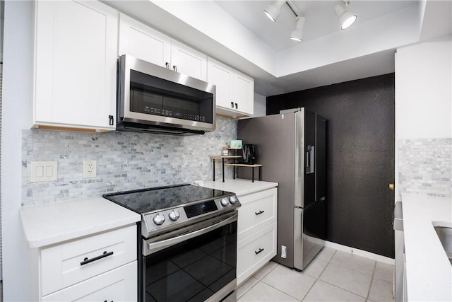 kitchen with stainless steel appliances, tasteful backsplash, white cabinets, and light countertops