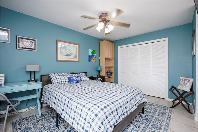 bedroom featuring a closet, light tile patterned floors, baseboards, and a ceiling fan