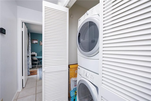 laundry room featuring stacked washer and dryer, light tile patterned flooring, and laundry area