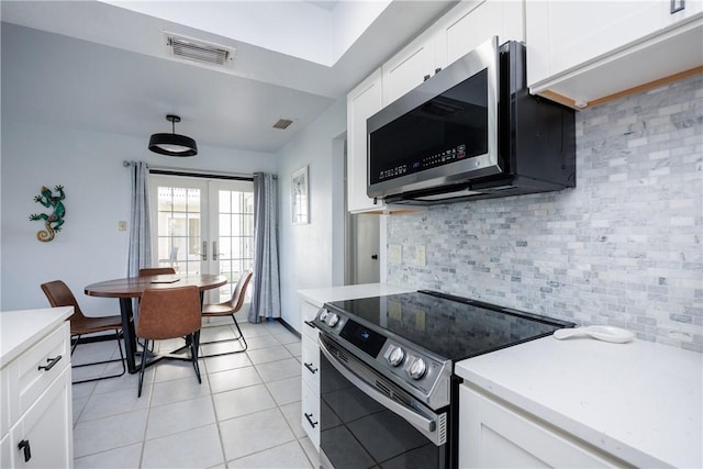 kitchen featuring visible vents, electric stove, french doors, stainless steel microwave, and tasteful backsplash