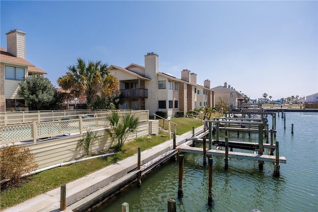 view of dock featuring boat lift, fence, and a water view