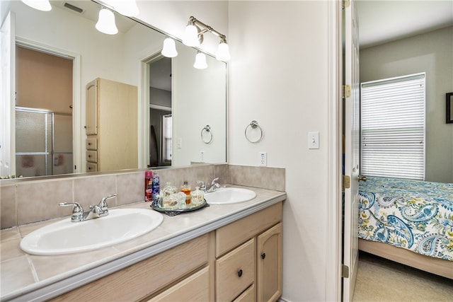 bathroom with a shower with shower door and vanity