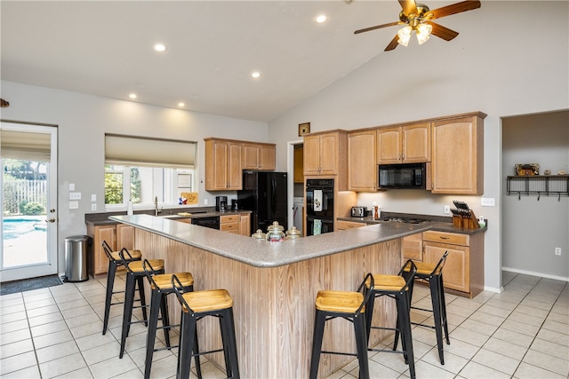 kitchen with black appliances, light tile patterned floors, high vaulted ceiling, ceiling fan, and a breakfast bar