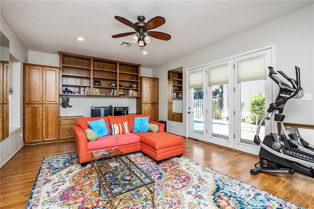 living room with ceiling fan and light hardwood / wood-style flooring