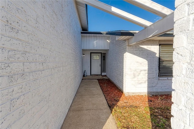 doorway to property featuring brick siding