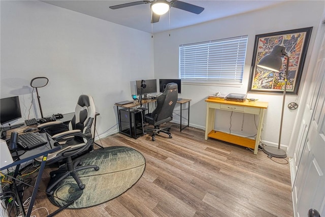 office featuring wood finished floors, a ceiling fan, and baseboards