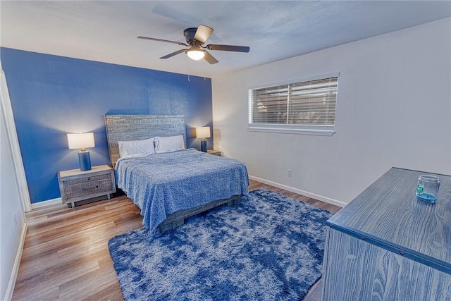 bedroom with ceiling fan, baseboards, and wood finished floors