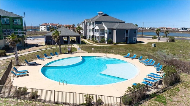 pool featuring a patio area, a yard, and fence