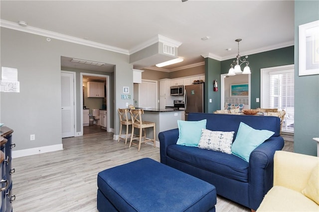 living room with light wood-type flooring, baseboards, visible vents, and ornamental molding