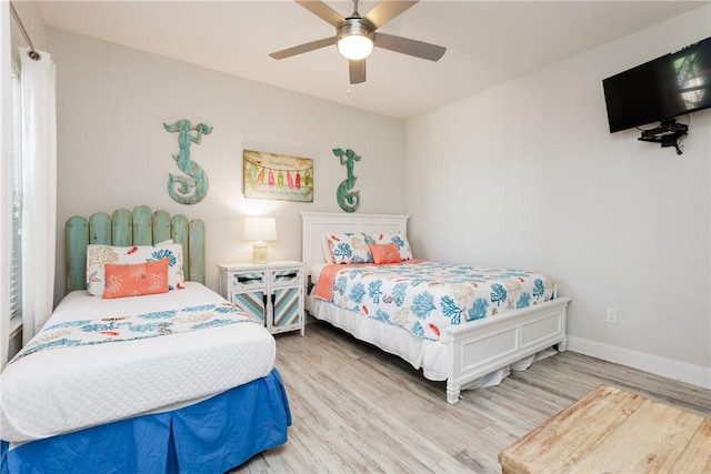 bedroom featuring a ceiling fan, wood finished floors, and baseboards