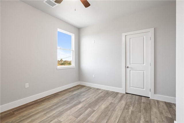 spare room with ceiling fan and light wood-type flooring