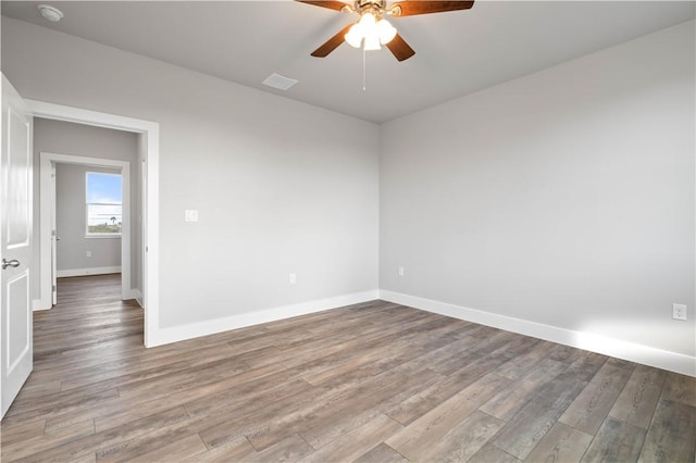 empty room with ceiling fan and hardwood / wood-style floors