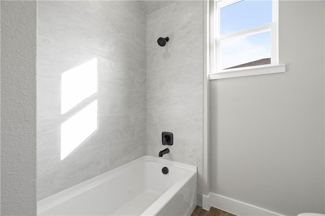 bathroom featuring hardwood / wood-style floors and tiled shower / bath