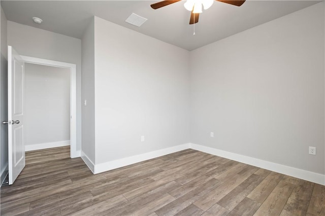 empty room with hardwood / wood-style flooring and ceiling fan