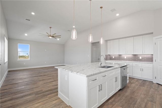 kitchen with stainless steel dishwasher, a kitchen island with sink, sink, white cabinetry, and hanging light fixtures