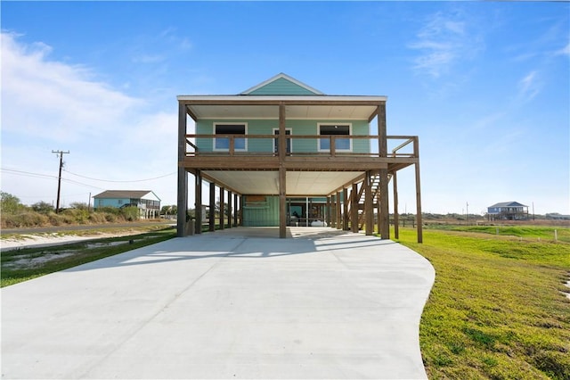 coastal inspired home with a carport and a front yard