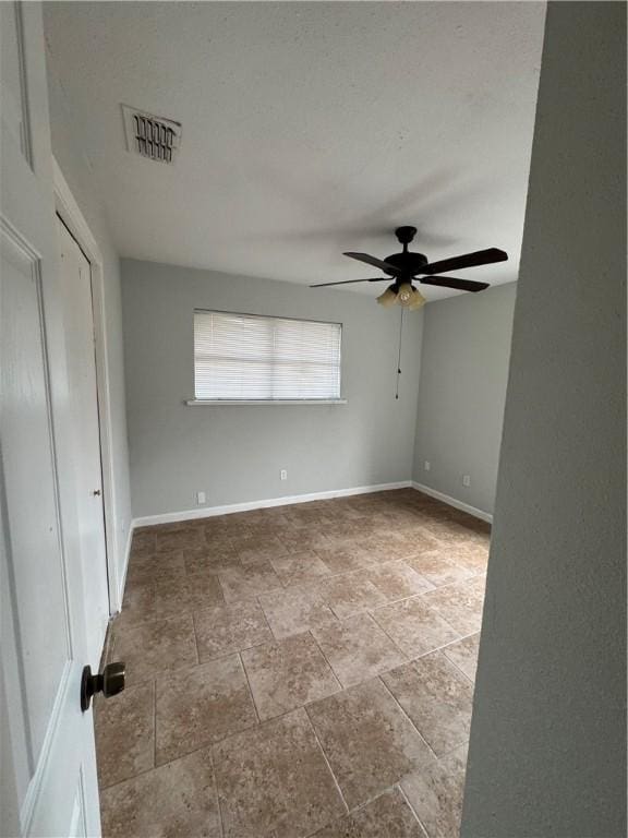 unfurnished bedroom featuring a ceiling fan, baseboards, and visible vents