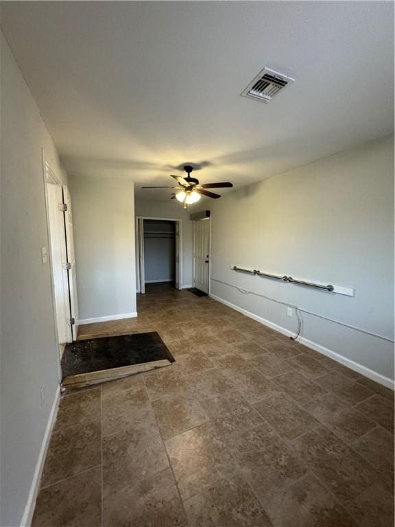 interior space with visible vents, a ceiling fan, and baseboards