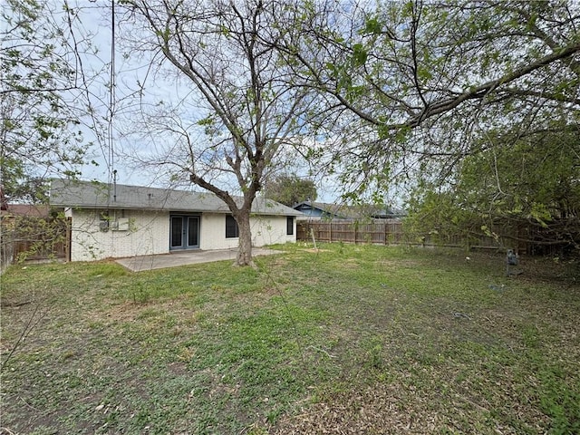 view of yard with a fenced backyard, french doors, and a patio