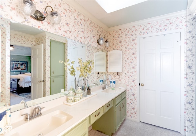 bathroom with vanity, ceiling fan, crown molding, and a skylight