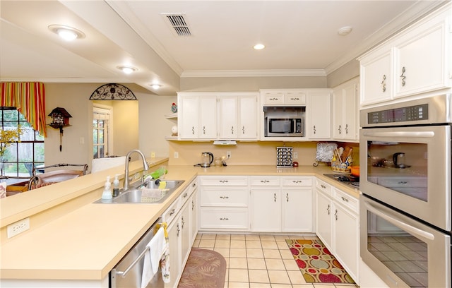 kitchen featuring stainless steel appliances, kitchen peninsula, sink, light tile patterned flooring, and white cabinetry