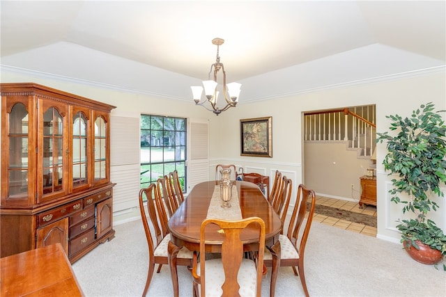 dining room featuring ornamental molding, light colored carpet, a raised ceiling, and an inviting chandelier