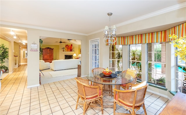 dining area featuring light tile patterned flooring, ceiling fan with notable chandelier, crown molding, and plenty of natural light