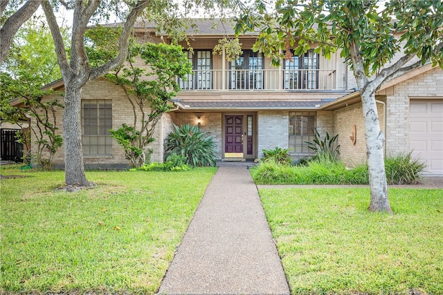 view of front facade with a front lawn, a balcony, and a garage