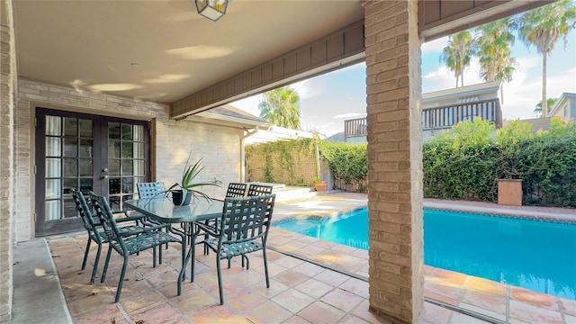 view of pool with french doors and a patio area