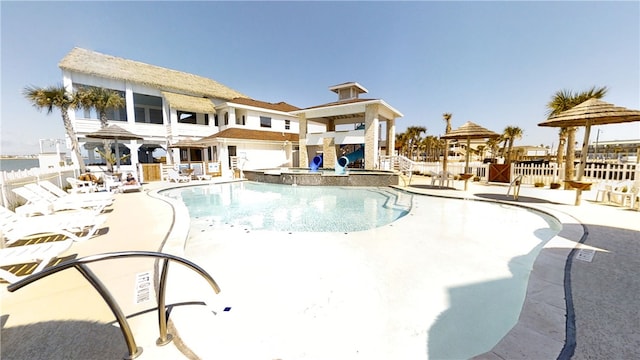 pool with a patio area and fence