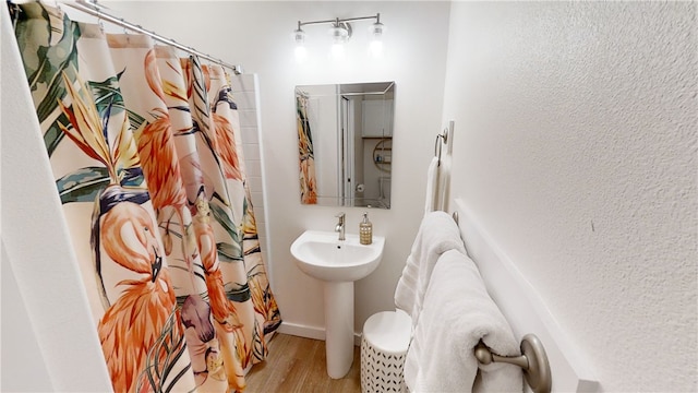 bathroom featuring a sink, wood finished floors, and a shower with curtain