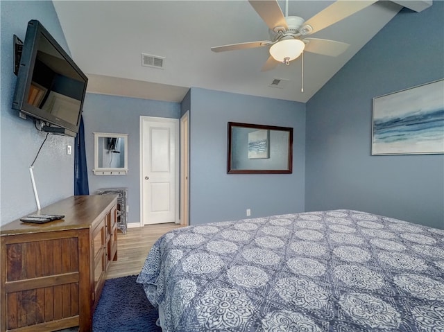 bedroom featuring light hardwood / wood-style floors, lofted ceiling, and ceiling fan