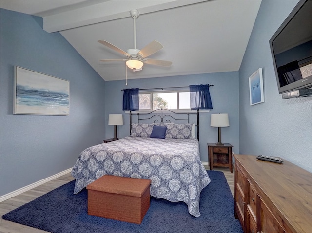 bedroom featuring light hardwood / wood-style floors, ceiling fan, and lofted ceiling with beams