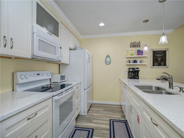 kitchen with decorative light fixtures, sink, white cabinets, white appliances, and light hardwood / wood-style flooring