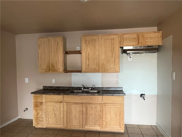 kitchen with light brown cabinets, sink, and dark tile patterned floors