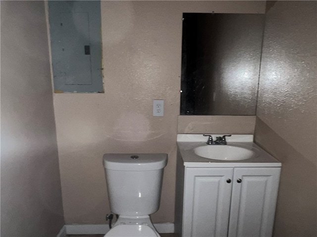 bathroom with electric panel, vanity, and toilet