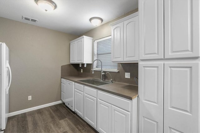 2718 Wind Rock Dr, Corpus Christi, TX 78410 - kitchen featuring white appliances, a sink, white cabinetry, dark wood-type flooring, and baseboards