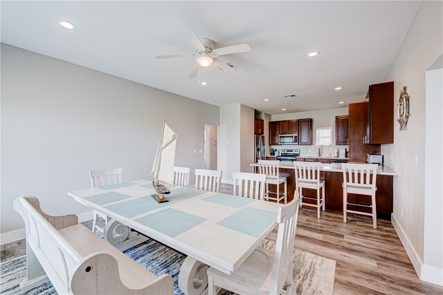 dining space featuring light wood-type flooring and ceiling fan