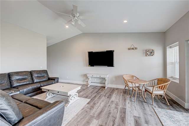 living room featuring light hardwood / wood-style flooring, lofted ceiling, and ceiling fan