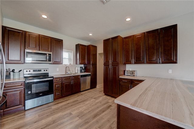 kitchen with light hardwood / wood-style floors, sink, and appliances with stainless steel finishes