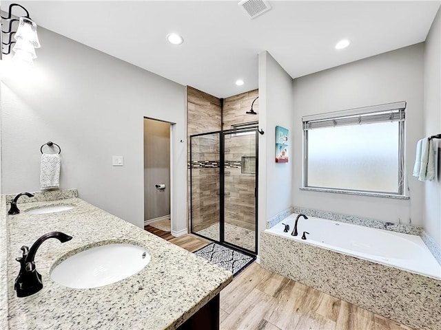 bathroom featuring wood-type flooring, vanity, and independent shower and bath