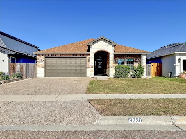 ranch-style house featuring a garage and a front lawn